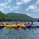 Savage-Rez-Kayak-Tours-with-All-Earth-Eco-Tours-great-fun-for-groups-Crede-Calhoun-photo A happy group of friends in kayaks on a beautiful mountain lake